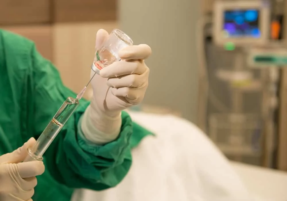 An experienced doctor in NYC administering epidural injection medicine to a patient, offering precise, non-surgical pain relief for back and nerve conditions.