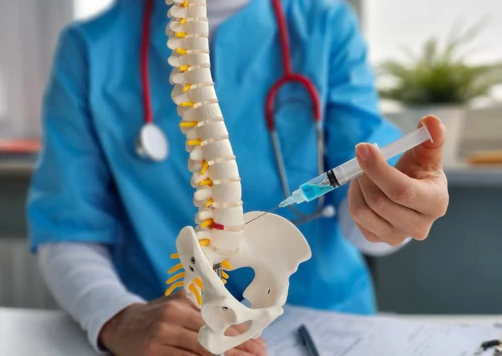 A pain management doctor from NY Spine Medicine in NYC performing a facet block spinal injection on a patient to relieve chronic back or neck pain, using precise, image-guided techniques.