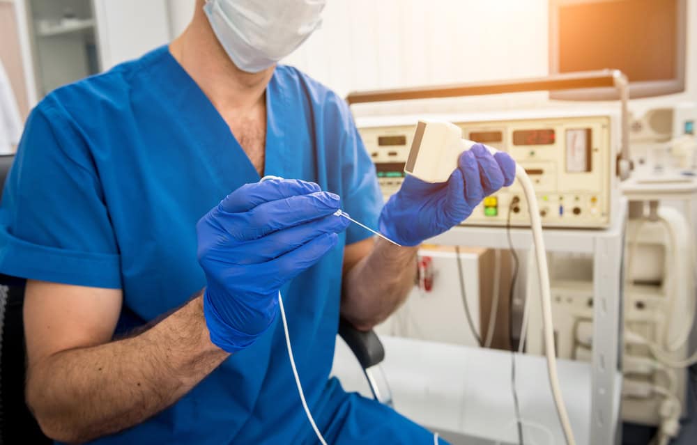 A pain management doctor in NYC performing a radiofrequency ablation procedure using image-guided equipment to precisely target nerves causing chronic spinal pain.