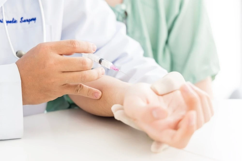 A neuropathy specialist in NYC administering a pain relief injection to a patient, highlighting interventional treatment for nerve pain and chronic neuropathy symptoms.