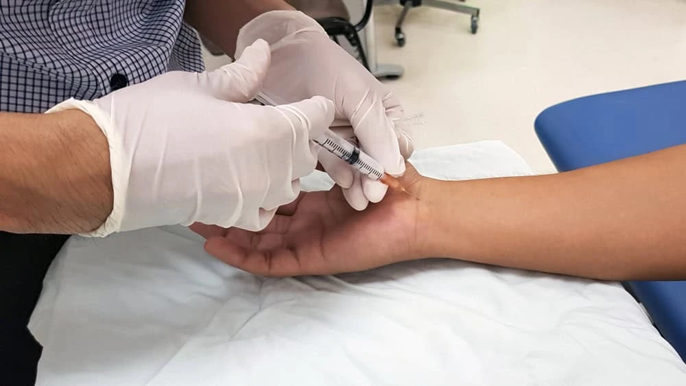A neuropathy medicine specialist in NYC administering a pain relief injection to a patient, representing advanced nerve pain treatment options for chronic neuropathy conditions.
