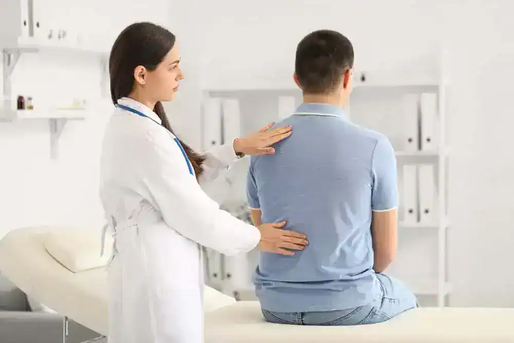 A female physiotherapist providing professional back pain therapy to a patient lying in a treatment bed at NY Spine Medicine in New York, focusing on manual techniques and guided rehabilitation for pain relief.